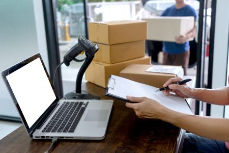 staff work together delivery the box logistic and use barcode scanner and computer ,with white computer screen with clipping path