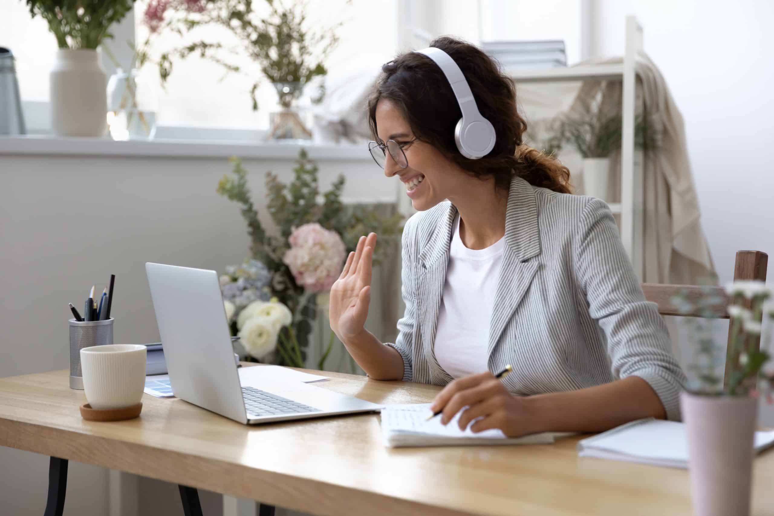Vrouw met koptelefoon neemt deel aan online evenement of vergadering.