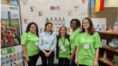 Vijf vrouwen in groene shirts bij COFEP-stand op Canadese handelsbeurs.
